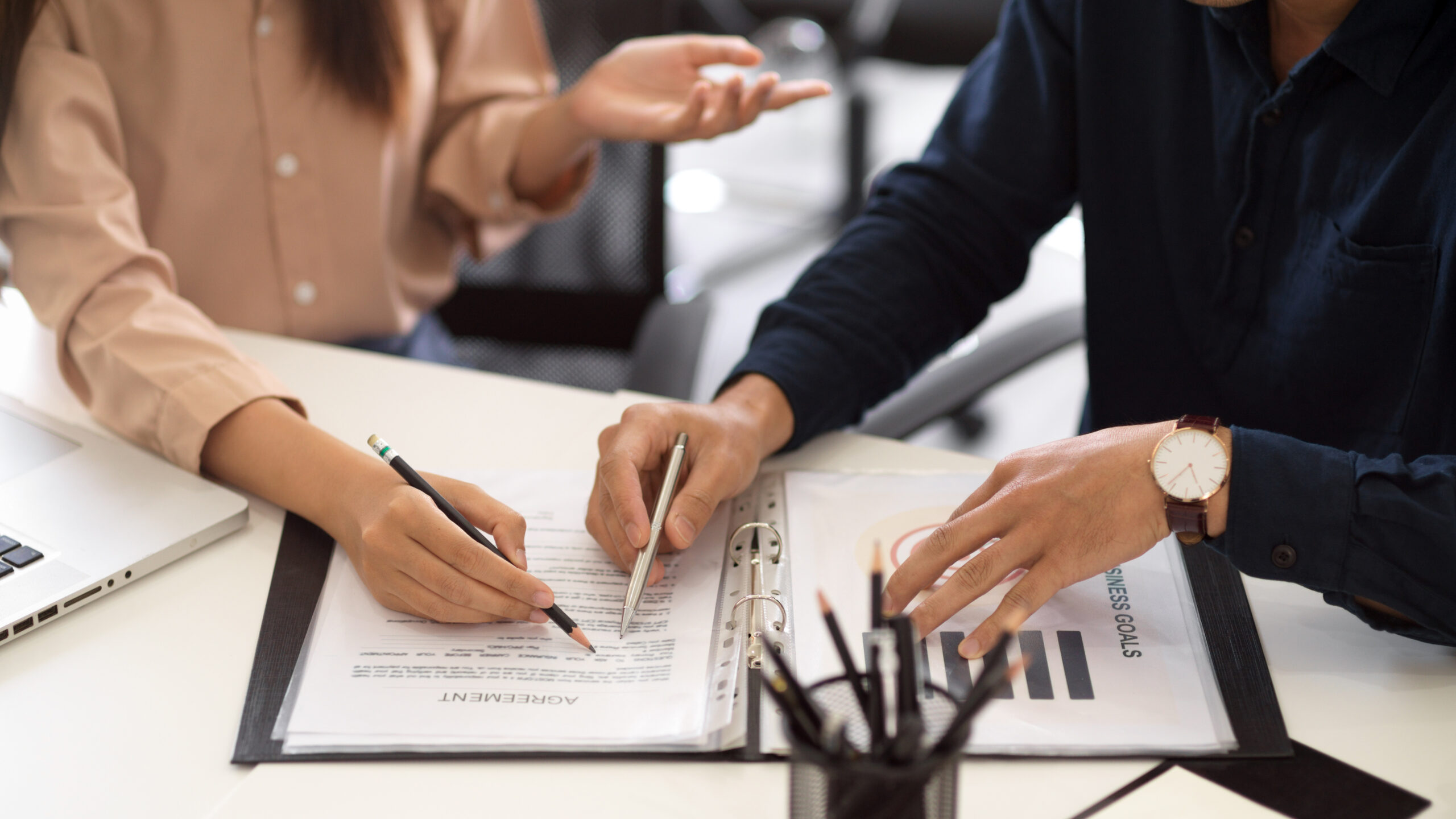 Two Businesspeople Discussing And Analysing Financial Document Two Businesspeople Discussing And Analysing Financial Document